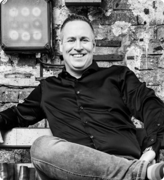 smiling man with jeans sitting on bench